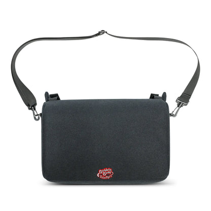 A black, rectangular travel bag for the BubbleBum TelePort booster seat, featuring an adjustable black shoulder strap attached by swivel hooks. The red and white BubbleBum TelePort logo is centered at the bottom of the bag. The bag has a clean, minimalist design intended for easy carrying while traveling.
