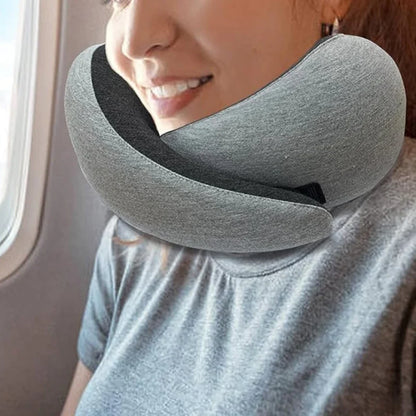 Woman using a gray ergonomic travel neck pillow on a flight.