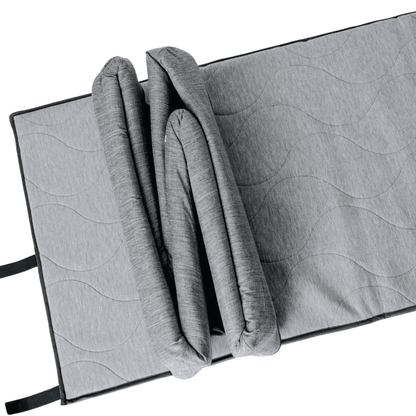 Gray quilted mat with a folded blanket on a white background