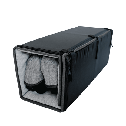 Black shoe storage bag with a gray interior containing a pair of shoes on a white background
